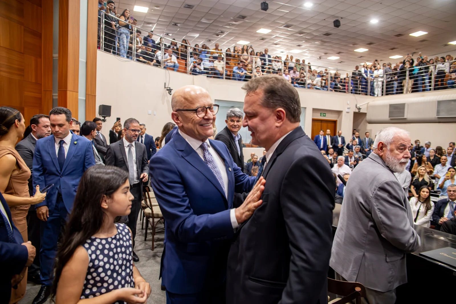 Otaviano Pivetta, de terno azul e óculos, cumprimenta convidado no plenário da Assembleia Legislativa de Mato Grosso durante sua posse como governador, em março de 2026