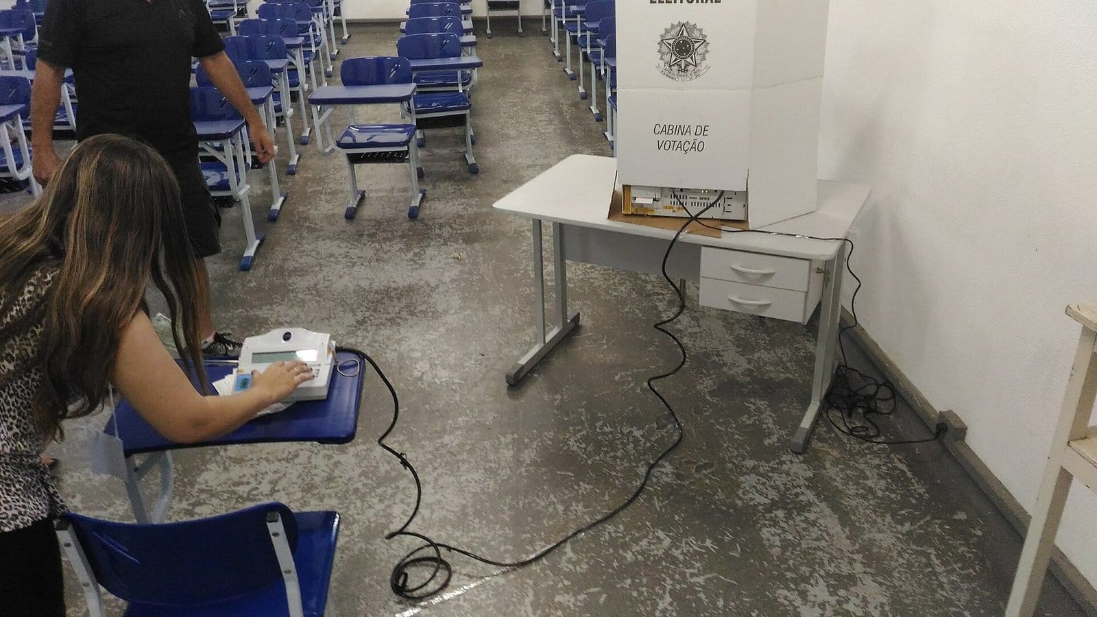 Mesária utiliza terminal do mesário para liberar urna eletrônica brasileira durante eleições municipais de 2016 em Itajubá, MG, Brasil.