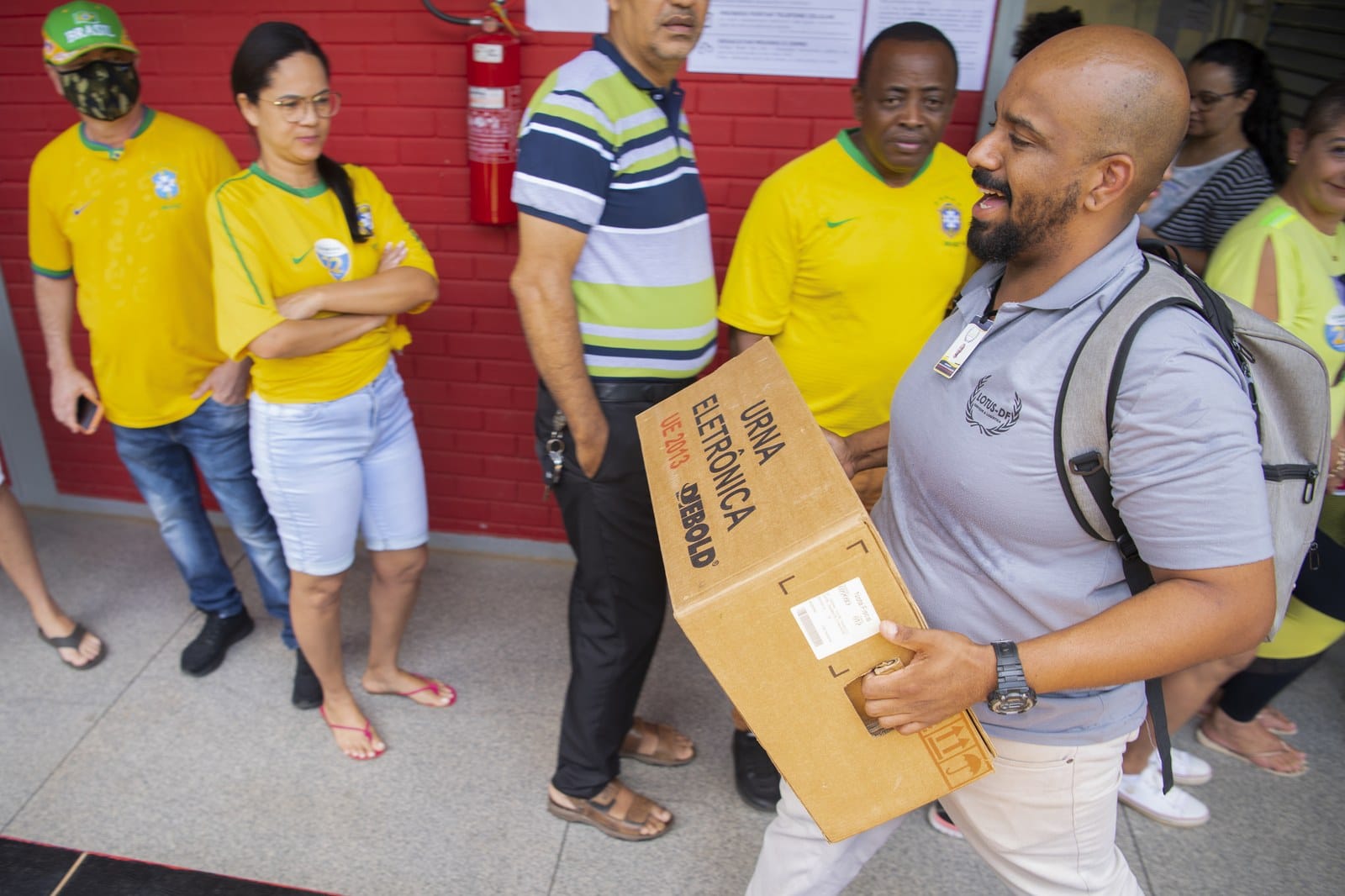Eleitor carrega caixa de urna eletronica em local de votacao