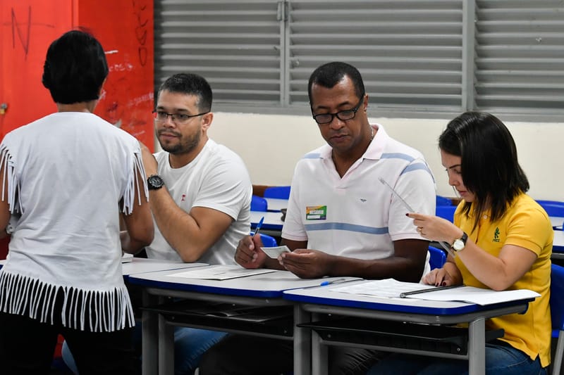 Mesarios atendem eleitora em secao de votacao