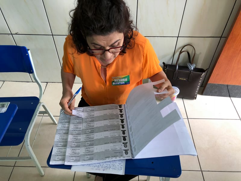 Mesaria confere caderno de votacao